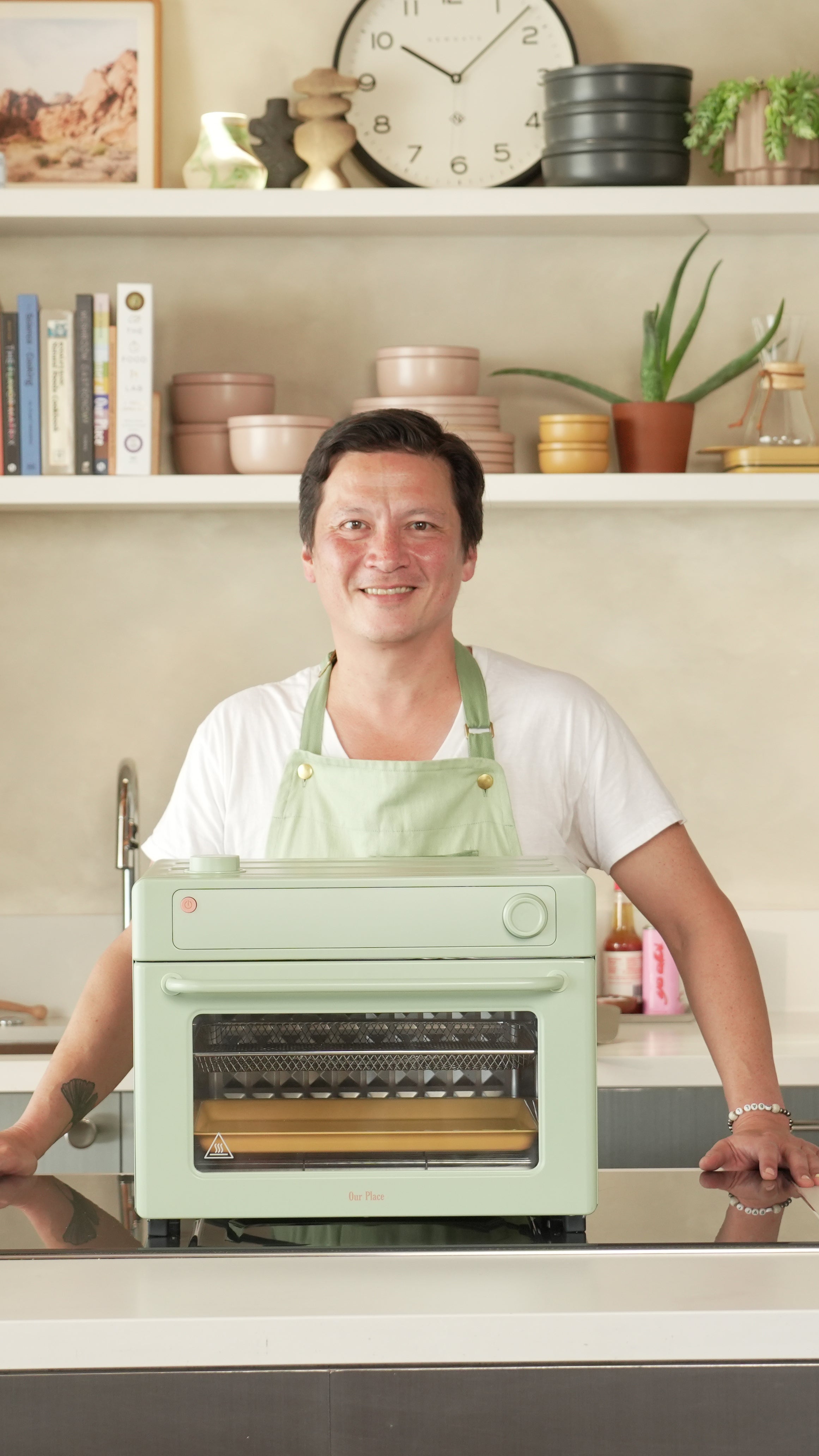 Kenji Lopez wearing green apron with green wonder oven pro