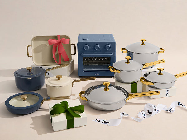 Set of cookware with lids and handles, including pots, a small oven, and gift boxes on a beige background.