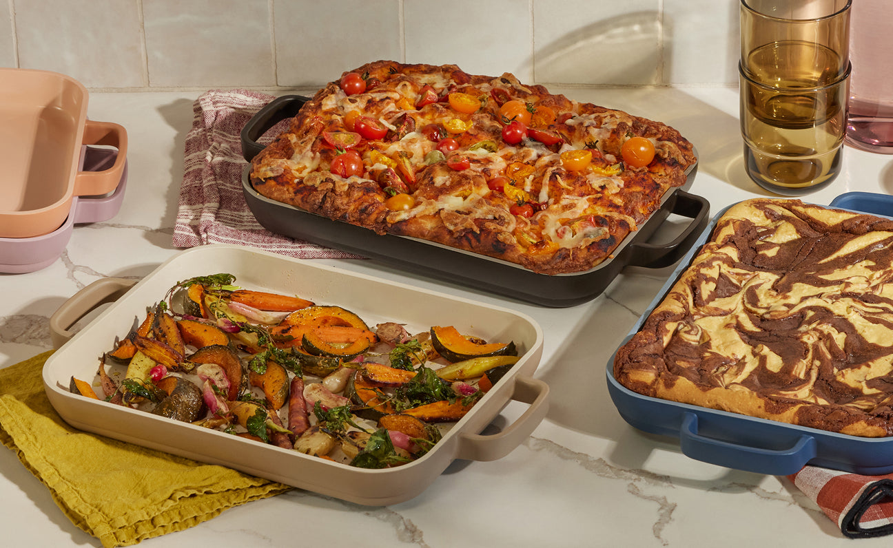 Three baked dishes on a kitchen counter with a tiled wall background